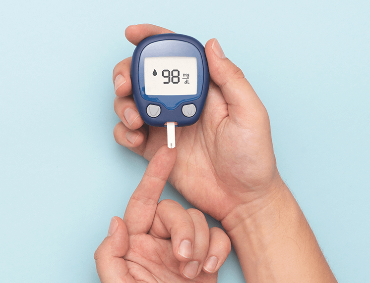 Glucose meter testing a finger prick reading 98 mg/dL