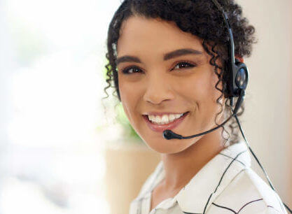 Young woman smiling at the camera with a headset on.